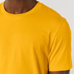 Detalle del cuello de canalé con cinta de refuerzo en una camiseta amarilla