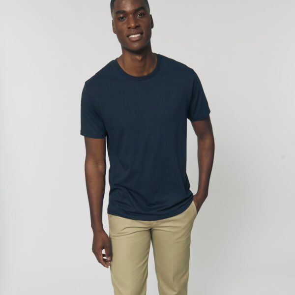 Hombre sonriente con camiseta tubular azul marino de algodón orgánico, lista para personalizar