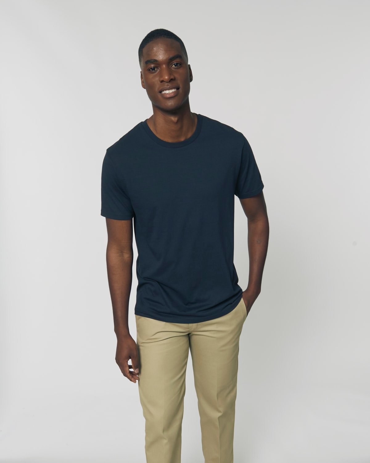 Hombre sonriente con camiseta tubular azul marino de algodón orgánico, lista para personalizar