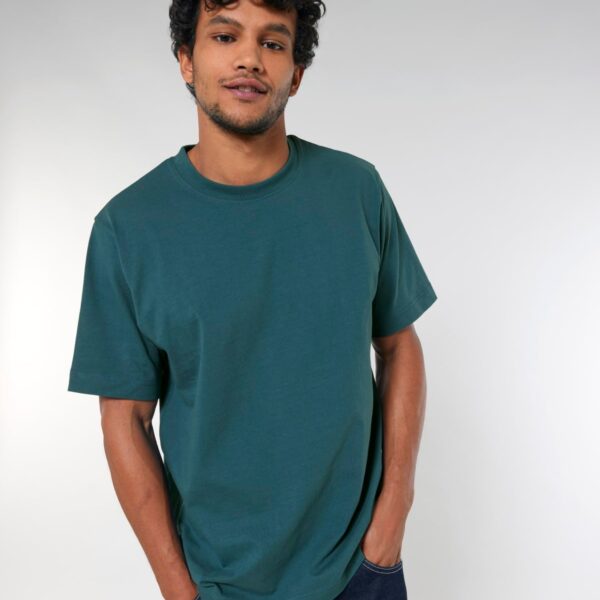 Hombre con camiseta oversize personalizable de algodón orgánico en azul petróleo, corte holgado