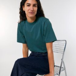 Mujer sentada con camiseta oversize de algodón orgánico azul petróleo
