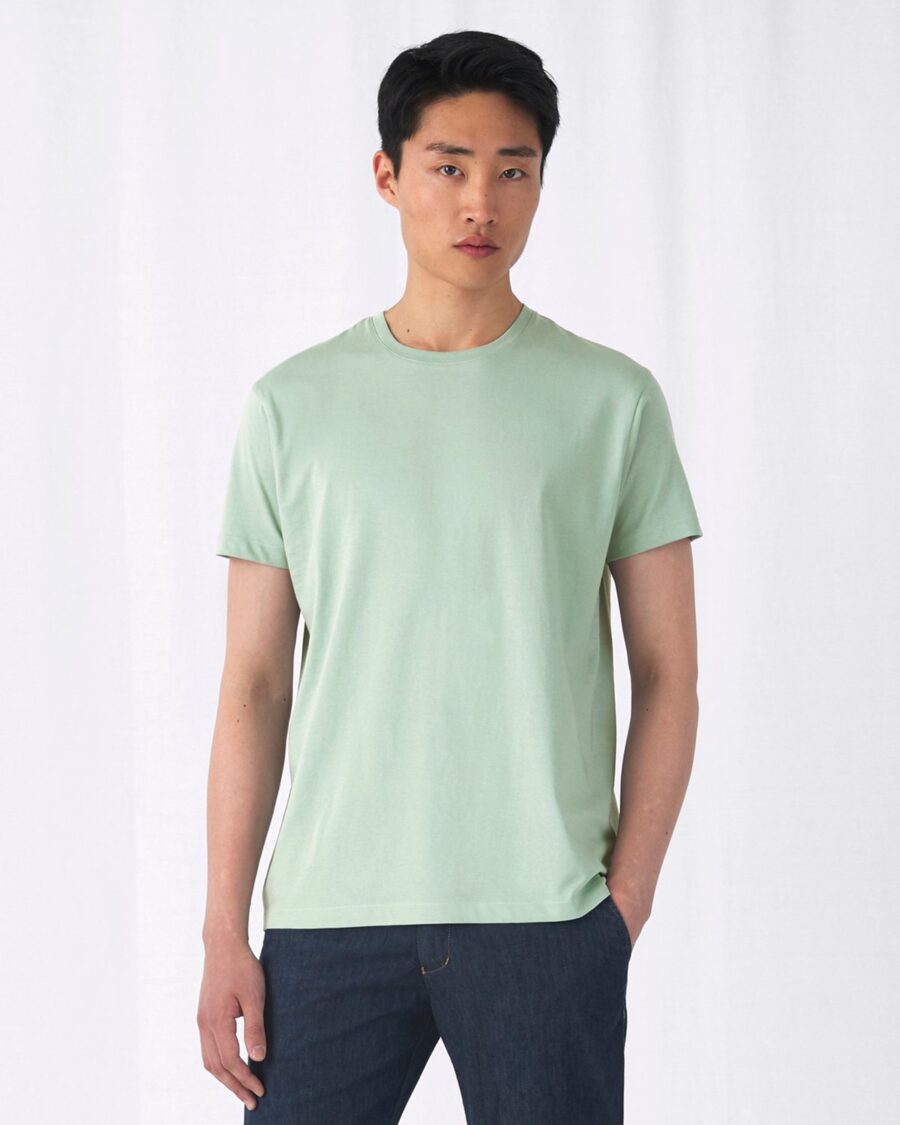 Camiseta básica ecológica unisex en verde salvia, vista de frente con modelo