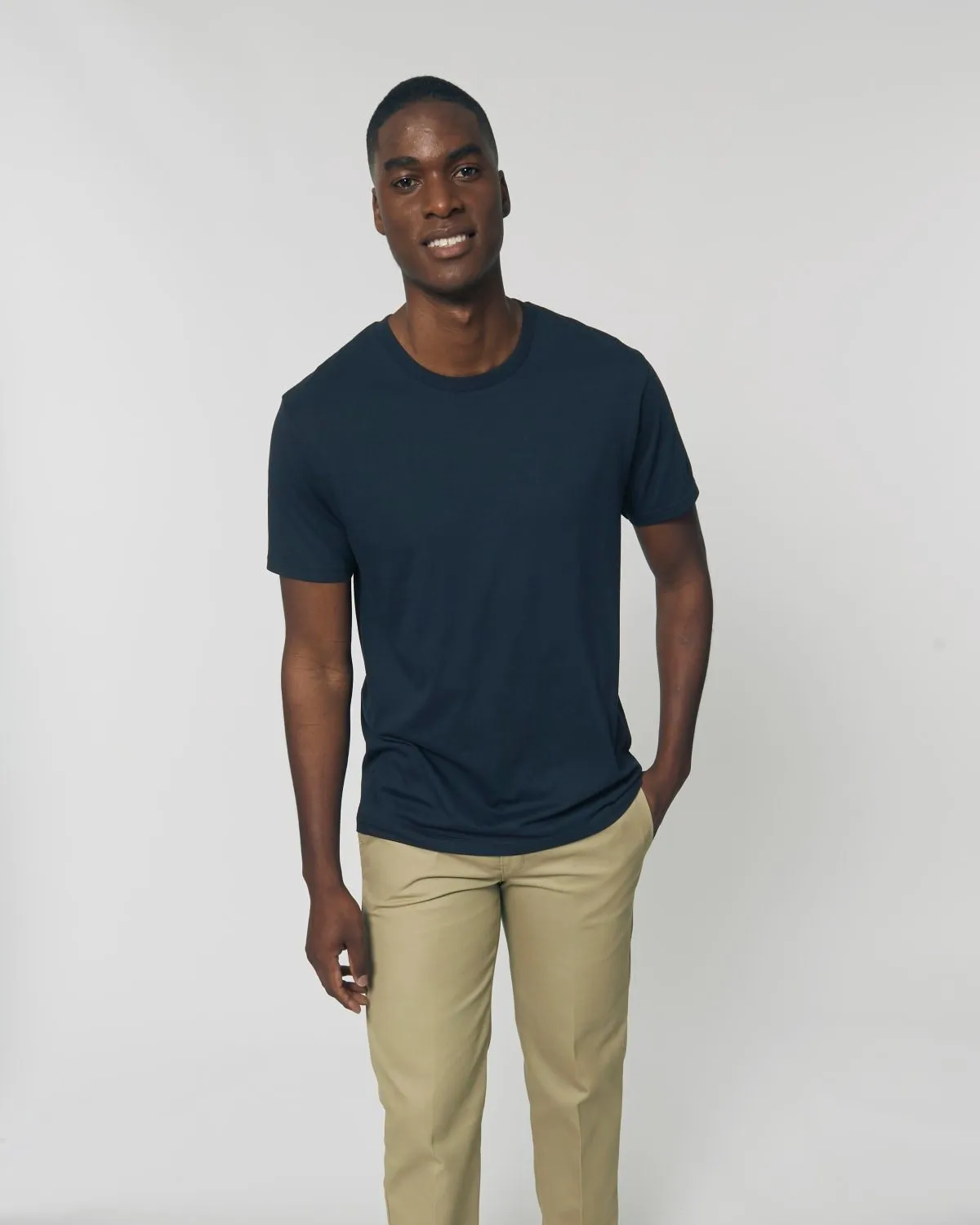 Hombre sonriente con camiseta tubular azul marino de algodón orgánico, lista para personalizar